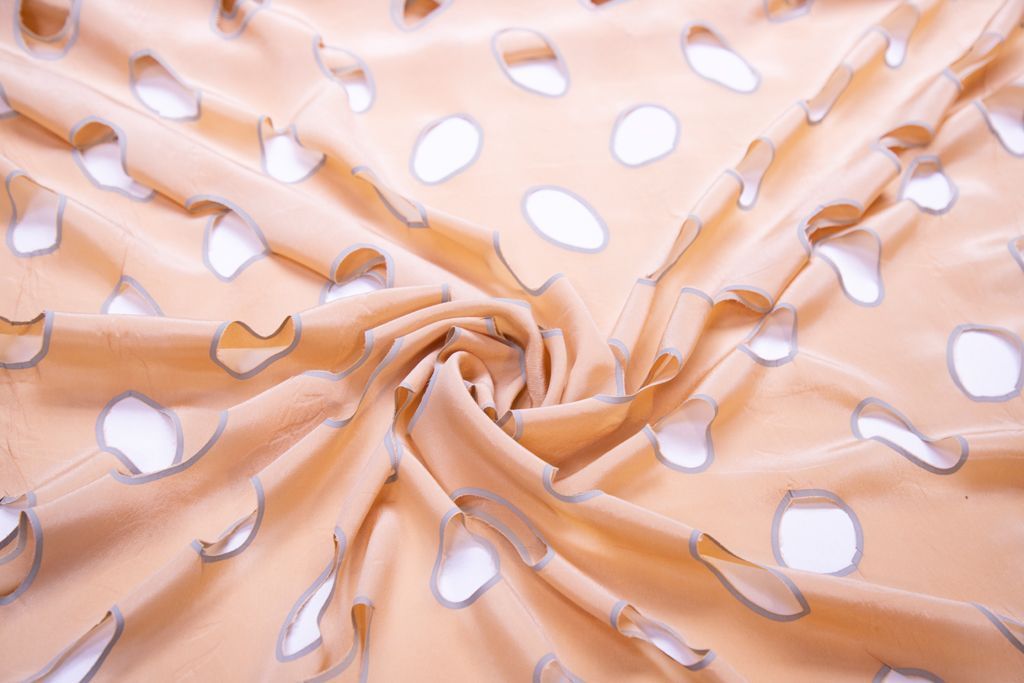 Блузочно-плательный шелк  с перфорированными кругами, фон персиковыйизображение